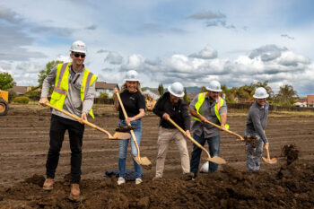 Photo of a groundbreaking ceremony for StorQuest Self Storage in Fairfield, CA. People are shown wearing Huff Construction hard hats and gold shovels as they celebrate the groundbreaking ceremony.