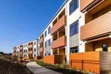 Exterior facade of Lightfighter Village showing balconies and a landscaped walkway