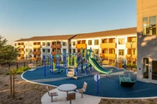 Community playground at Lightfighter Village with residential building in the background